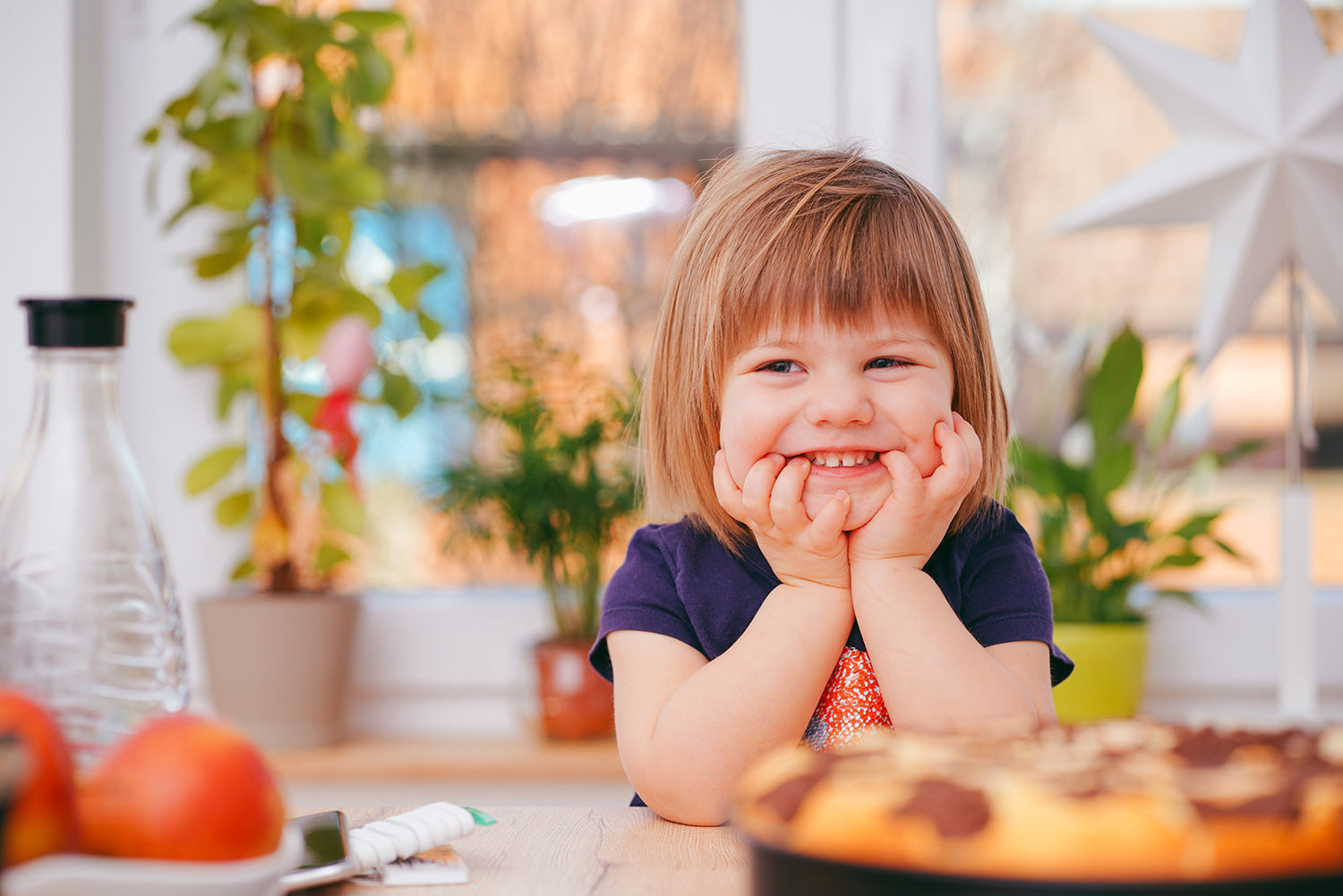 Child smiling at food on the counter